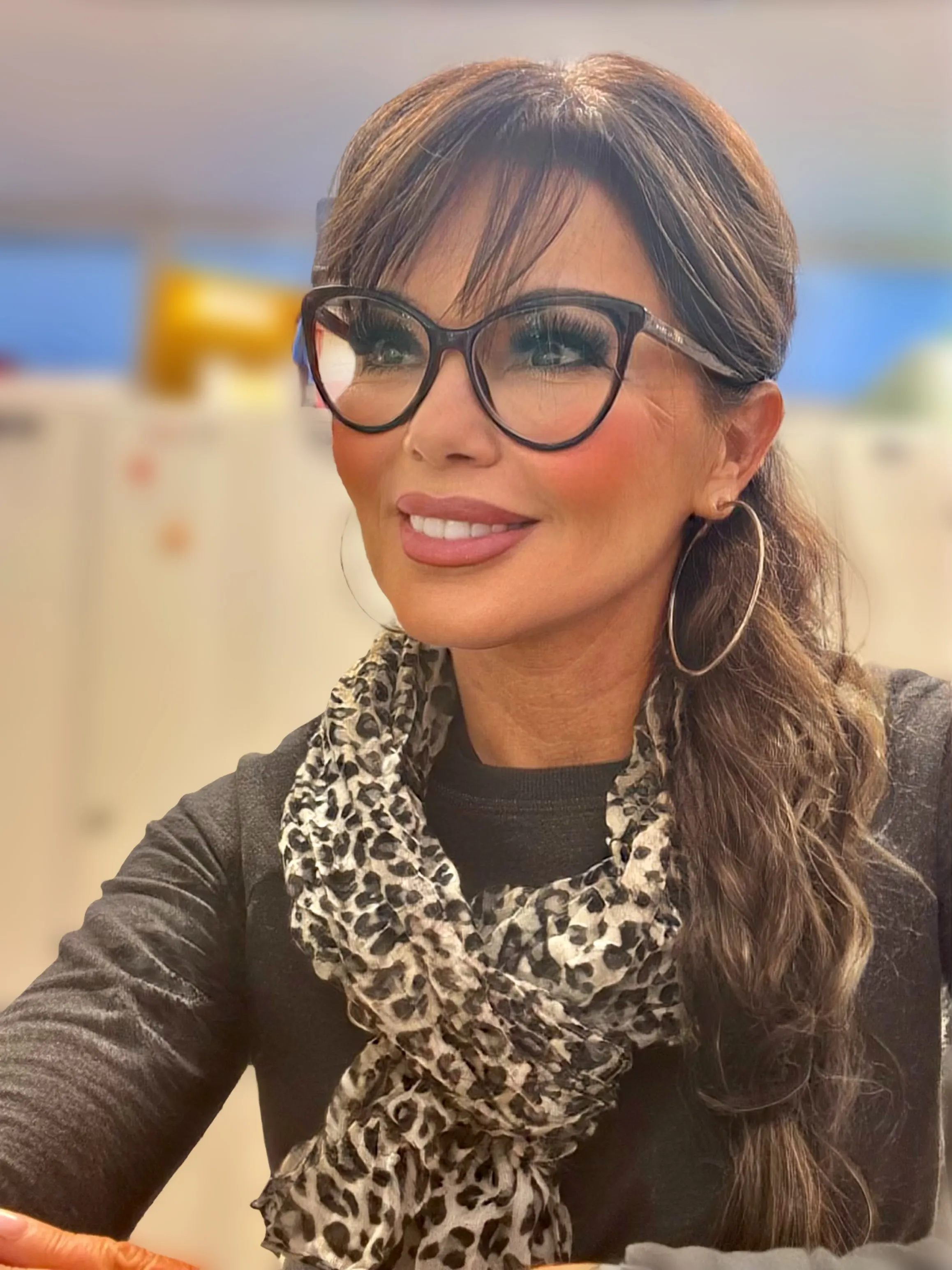 Portrait de Lory Anthoine, souriante, lunettes et foulard.